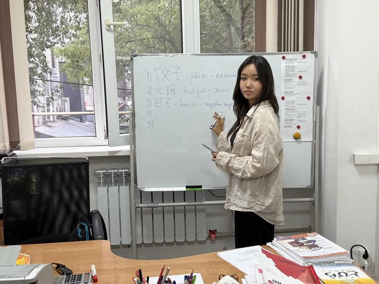 Преподаватель китайского языка у доски с иероглифами — ROMANATA Academy, Алматы